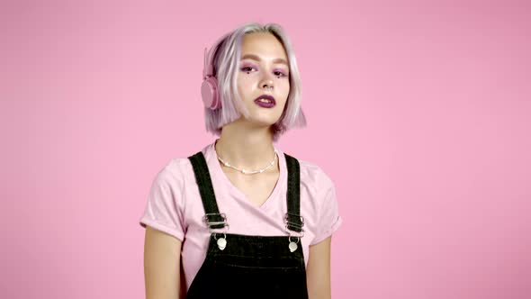 Pretty Girl with Dyed Violet Hair Listening To Music, Smiling, Dancing in Headphones in Studio alt