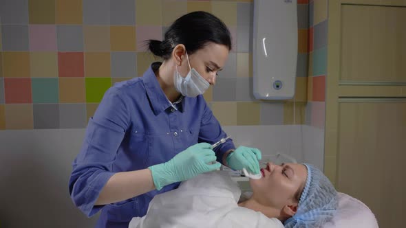 The Master Performs a Procedure of Lip Correctio with Hyaluronic Acid in Studio alt