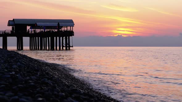 Panorama of the Sunset Over the Sea Next To the Silhouette of the Pier. alt
