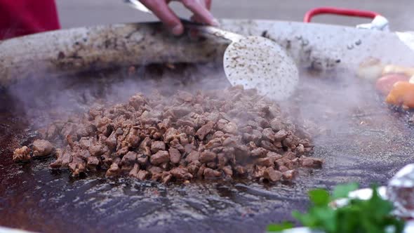 Pieces of Meat Are Roasted in Oil Lose-up in the Fresh Air. alt