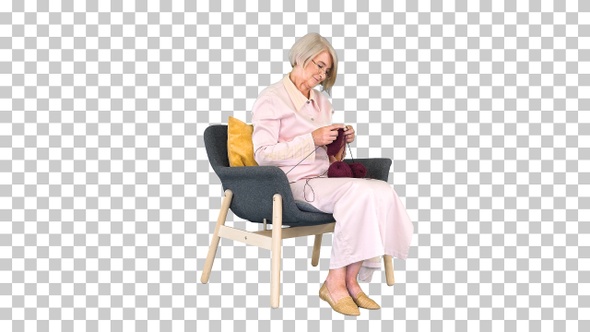 Elderly woman in glasses knits clothes, Alpha Channel alt