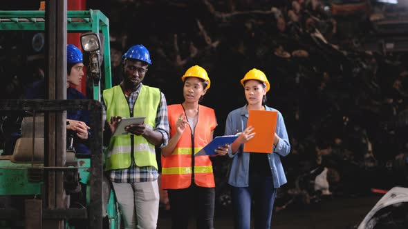 African and Asian factory worker women come to discuss with other co-worker men alt