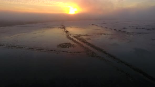 Sunset over the misty lake, view from a drone alt