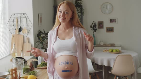 Joyous Pregnant Woman with Progress Bar on Belly Dancing at Home alt