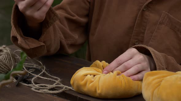 Woman make handmade pumpkins made of fabric on wooden table