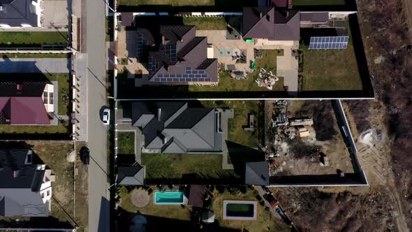 aerial view of houses on Ukraine housing estates, some with building on roof panels. alt