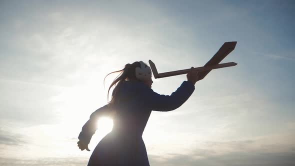 Cute Child Playing with Toy Wooden Airplane in the Field at Sunset Time, Silhouette of Kid Playing alt