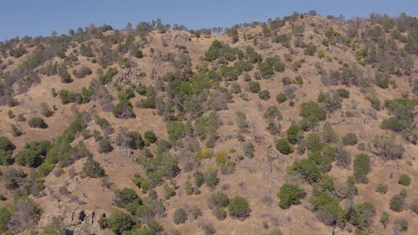 Aerial Drone Shot Ascending Over the Top of a Mountain to Reveal Vast Rolling Hills  in California