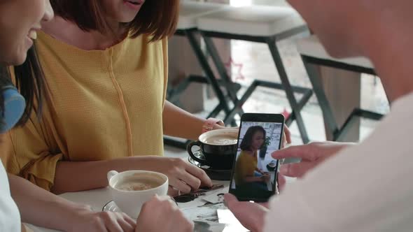 Three Friends Watching Video in Café alt