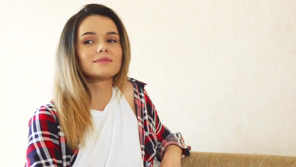 The Young Girl Is Sitting at Home alt