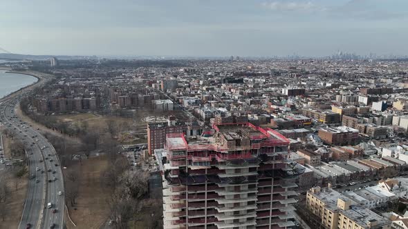 A high angle view above a new high-rise construction site with Shore Parkway and the Verrazano bridg alt