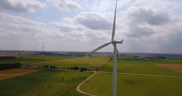 Static aerial shot of a rotating wind turbine alt