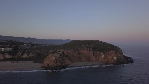 AERIAL: Flight Over Malibu, California View of Beach Shore Line Pacific Ocean at Sunset with alt