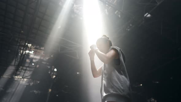4K Asian woman boxer practicing boxing exercise punching the air in abandoned building. alt