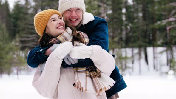 Happy Smiling Couple Having Fun in Winter Forest