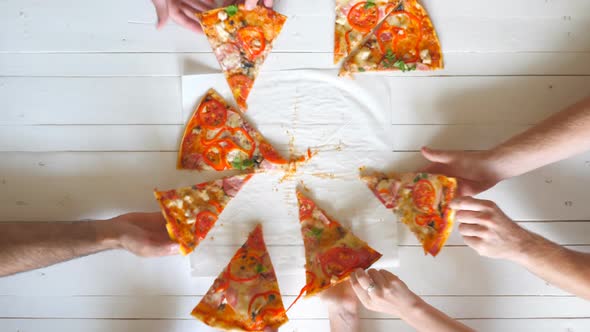 Top View Male and Female Hands Taking Slices of Pizza with Cheese, Tomatoes and Ham From Food alt