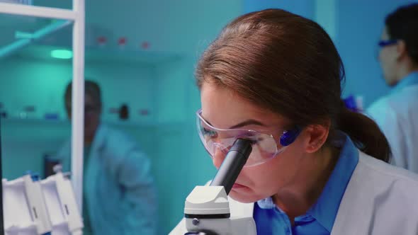 Close Up of Chemist Woman Doctor Looking Through Microscope alt