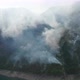 Clouds of white smoke from a fire backlit by sun, caused by burning forest due to climate change - VideoHive Item for Sale