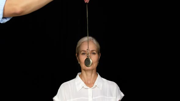 Woman mesmerised by a pendulum movement alt