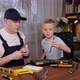 Handsome Bald Man Showing Instruments to His Son While Sitting at the Table - VideoHive Item for Sale