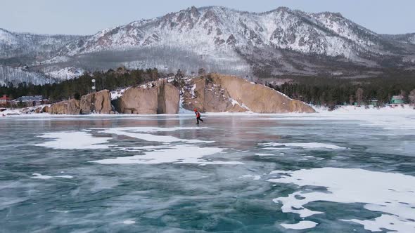 Aerial View of Man Skating on Lake Baikal Covered By Ice alt