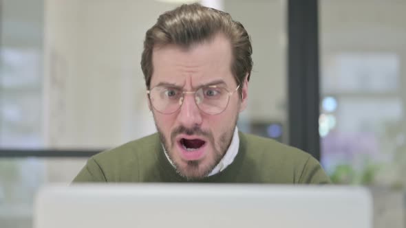 Close Up of Young Businessman Reacting to Loss on Laptop alt