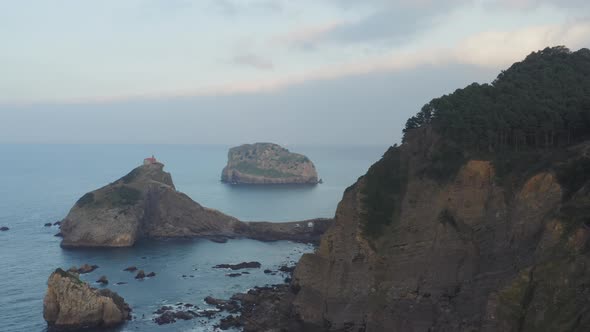 View of Bakio beach, resort city and Gaztelugatxe monastery, north coast of Spain at sunset