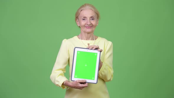 Beautiful Happy Senior Businesswoman Showing Digital Tablet alt