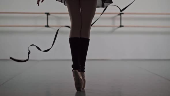 Closeup of Ballerina Feet in Pointe Shoes and Black Dress Dancing Ballet Elements Slow Motion alt