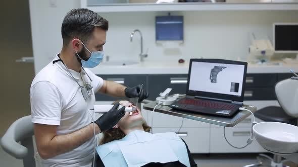 The Dentist Scans the Patient's Teeth with a 3d Scanner alt