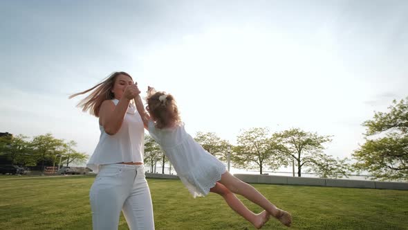 Mother and Daughter in the Park on a Spring Walk on Sunny Day alt