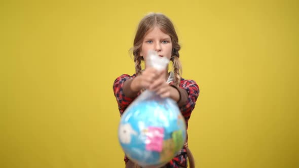 Front View Serious Female Adolescent Ecoactivist Looking at Camera Stretching Earth Globe in Plastic alt