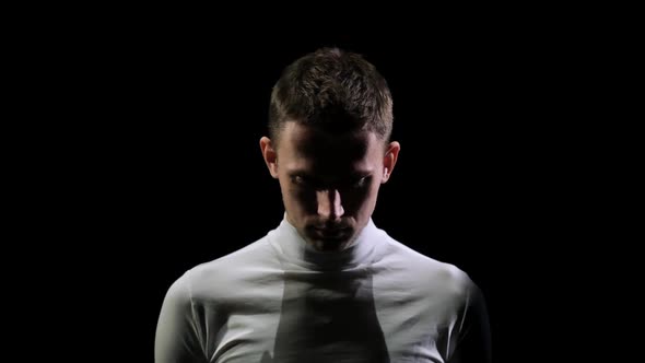 Front View of a Man in White Clothes Looking Down and Set Up Psychologically To Start the alt