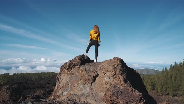 Young Woman Tourist Climbed to the Top of a Volcanic Stone alt