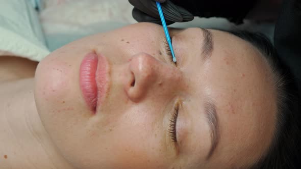 Eyelash Extension Master Combing Eyelashes to Client Before Extension alt