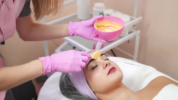 Young woman gets beauty facial injections in salon. alt