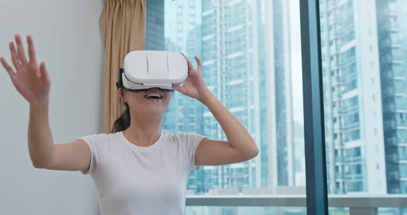 Woman watch on VR device at home alt