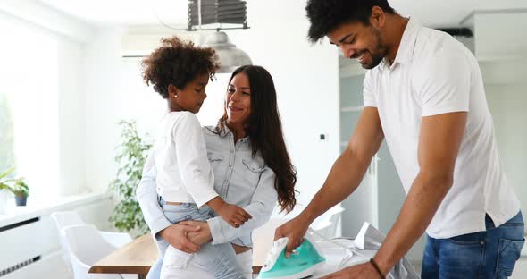 Young Couple at Home Doing Hosehold Chores and Ironing alt