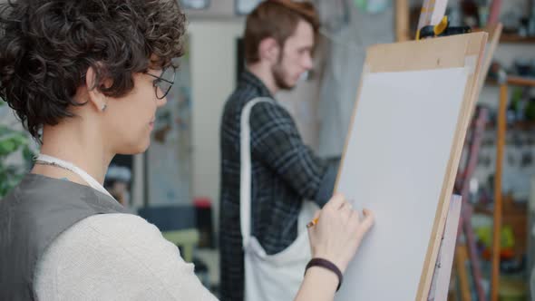 Man and Woman Art Students Drawing Pictures During Painting Lesson in Studio alt