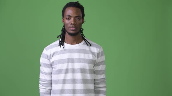 Young Handsome African Man with Dreadlocks Against Green Background alt