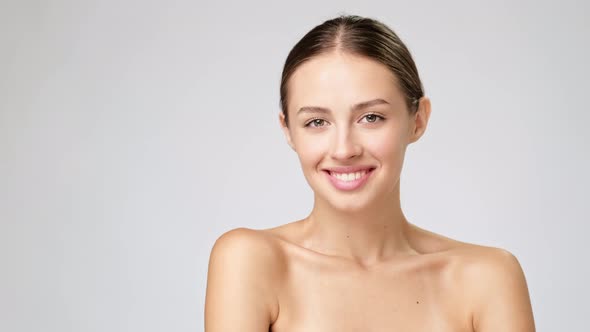 Beautiful Young Woman with Clean Fresh Skin Standing Over Light Grey Background alt