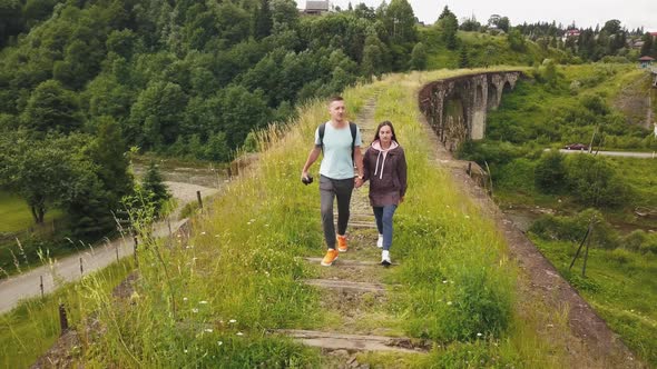 A couple walks along the old viaduct in the mountains Ukrainian Carpathians