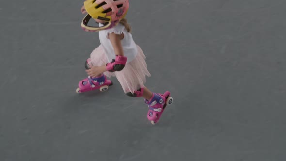 Teenage Girl Rollerblading in Skatepark alt