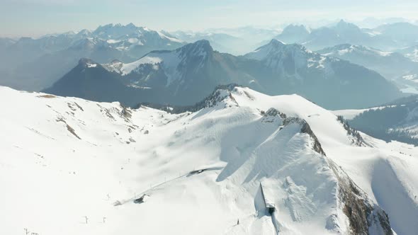 Aerial tilt up of beautiful snow covered mountain summit and revealing a stunning view of the Swiss alt