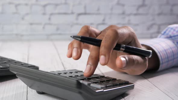 Close Up of Man Hand Using Calculator  alt