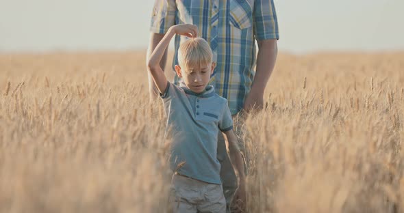 Happy Son Walking in the Field with His Father