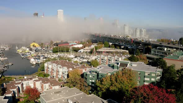Aerial rise over the picturesque Vancouver waterfront on a foggy morning alt