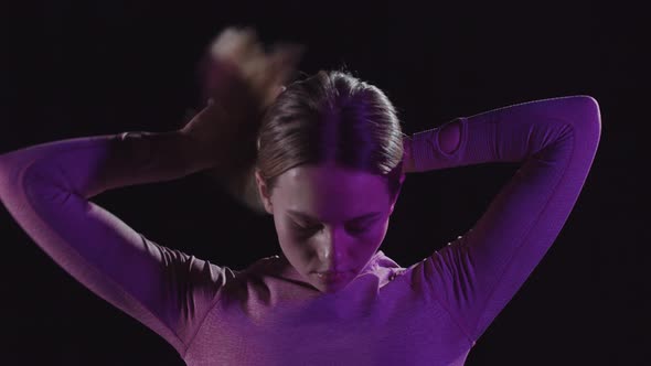 Young Woman in Pink Clothes Putting Her Hair in a Bun  Neon Lighting alt
