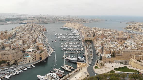 Aerial footage of the harbors of 'Three Cities of Malta' along the coast of the Mediterranean Ocean alt