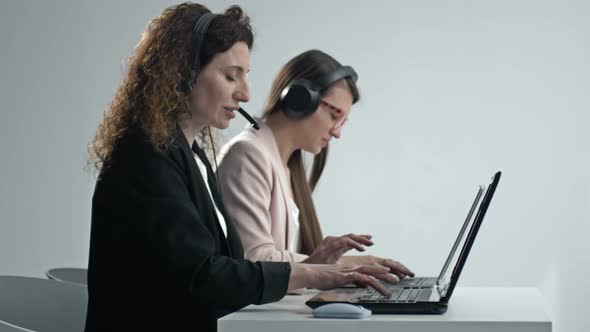Customer Support Agent or Call Center with Headset Works on Desktop Computer While Supporting the alt
